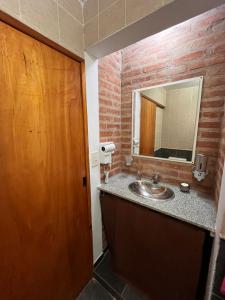 a bathroom with a sink and a wooden door at Cabañas Don Lelio 2 in Mina Clavero +8 photos