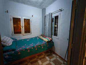 une petite chambre avec un lit dans une pièce avec deux fenêtres dans l'établissement قرية النورس, à Ismaïlia