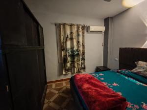 une chambre avec un lit avec une couverture rouge dessus dans l'établissement قرية النورس, à Ismaïlia