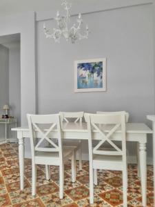 una sala da pranzo con un tavolo bianco e sedie bianche di En el centro entre el puerto y las playas a Gijón