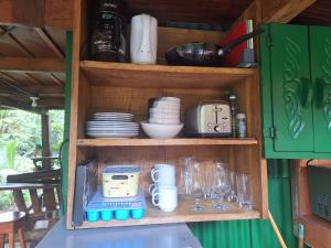 a wooden cabinet with dishes and glasses on it at Cabins river blue in Rio Celeste +16 photos