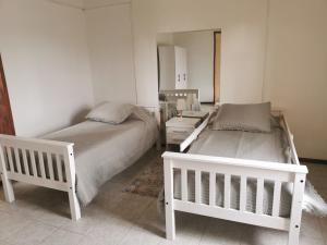 a bedroom with two beds and a mirror at Lo de Mary in Rocha +1 photo