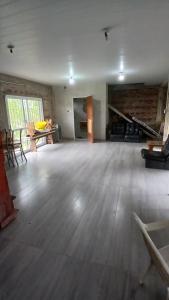 ein leeres Zimmer mit Holzboden und einem Tisch in der Unterkunft casa fin de semana in Paraná