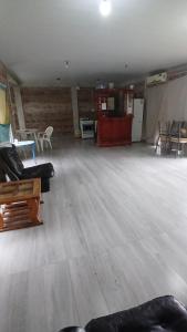 ein leerer Raum mit Sofas, Tischen und Stühlen in der Unterkunft casa fin de semana in Paraná