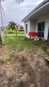 ein Hinterhof mit einer roten Bank in der Unterkunft casa fin de semana in Paraná