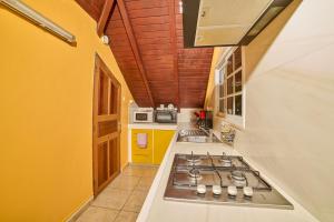 Eine Küche mit Herdplatte und gelben Wänden in der Unterkunft Le Flamboyant in Saint-Louis + 1 Foto