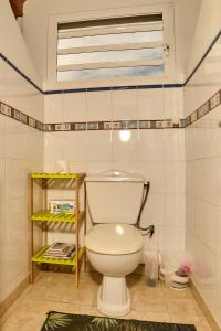 ein Badezimmer mit einer weißen Toilette in einem Zimmer in der Unterkunft Le Flamboyant in Saint-Louis