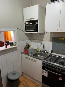 eine kleine Küche mit Herd und Spüle in der Unterkunft Arriendo a diario casa en pleno centro de Ovalle in Ovalle + 9 Fotos