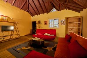 ein Wohnzimmer mit einem roten Sofa und einem Tisch in der Unterkunft Le Flamboyant in Saint-Louis