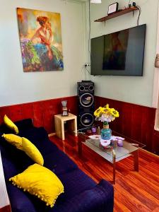 ein Wohnzimmer mit einem blauen Sofa und einem Fernseher in der Unterkunft Arriendo a diario casa en pleno centro de Ovalle in Ovalle