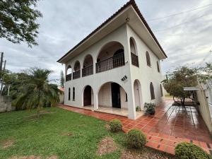 a large white house with a courtyard at Pousada Dona Lidia Express in Campo Mourão