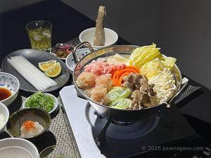 a bowl of food on a table with other foods at Guesthouse PAW in Nagano +5 photos