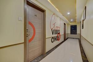 a hallway with a door and a sign on the wall at Townhouse Oak Pune Railway Station Formerly Kapil Residency in Pune