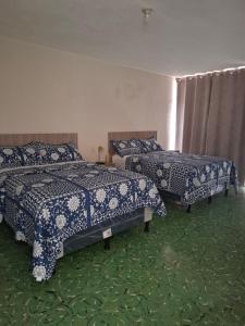 a bedroom with two beds with blue and white blankets at Hotel villa 15 in Las Victorias