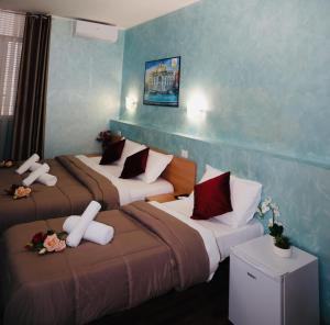 2 Betten in einem Hotelzimmer mit Blumen darauf in der Unterkunft Dreamland Guesthouse in Rom