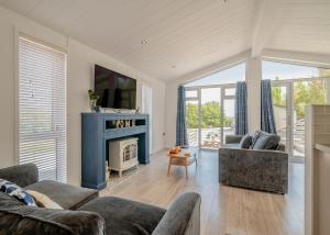 - un salon avec une cheminée bleue et des chaises dans l'établissement Henfields Country Retreat, à Otterhampton 83 autres photos