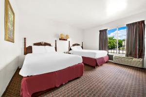 Ένα ή περισσότερα κρεβάτια σε δωμάτιο στο Capitol Inn & Suites