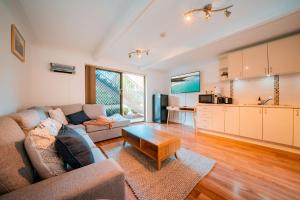 a living room with a couch and a table at Mollymook Beach getaway in Mollymook