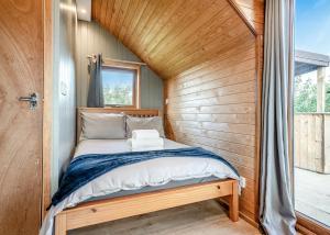 a bed in a small room with a wooden wall at South View Retreat in Carlton