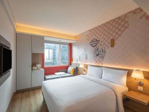 a bedroom with a large white bed and a kitchen at ibis Mumbai Vikhroli - An Accor Brand in Mumbai