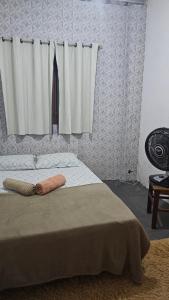 a bedroom with a bed with two towels on it at Aconchego da cris in Lençóis