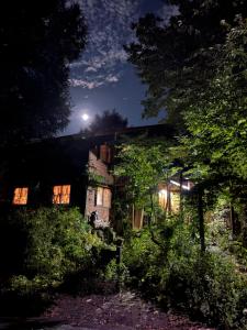 an old house at night with the moon behind it at 蔵王ペンション kobaya in Kaminoyama