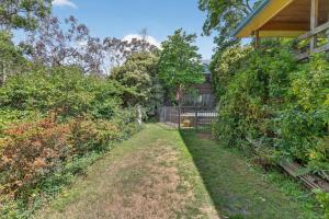 une cour avec une clôture à côté d'une maison dans l'établissement Natures Haven Wentworth Falls with Sauna & Pool, à Wentworth Falls