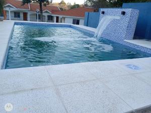 a swimming pool with a water fountain at Departamentos Elisabeth in Tanti