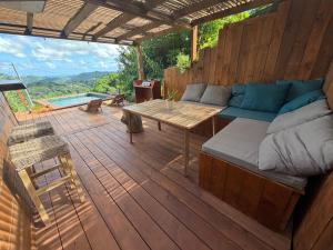a patio with a couch and a table on a deck at Chill lodge in Sainte-Luce