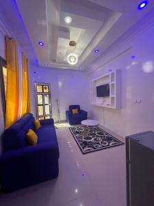 un salon avec un canapé bleu et une télévision dans l'établissement Préférence, à Dakar