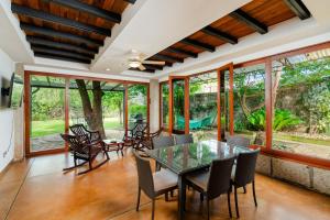 a dining room with a glass table and chairs at Casa Milo in Managua