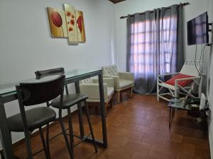 a living room with a glass table and chairs at Iguazú Cataratas Dpto2 in Puerto Iguazú