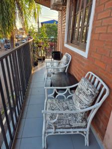 a patio with two chairs and a table on a balcony at Iguazú Cataratas Dpto2 in Puerto Iguazú +2 photos