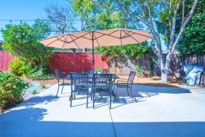 une table et des chaises sous un parasol sur le trottoir dans l'établissement Spacious SJ 4BR Home Prime Location Near Everything, à San José