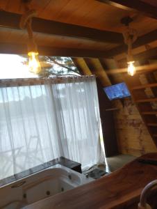 een badkuip in een kamer met een raam bij Chalé do lago in Campo Alegre