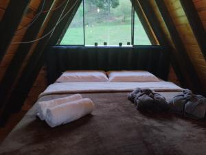a bed in a room with a window at Chalé do lago in Campo Alegre