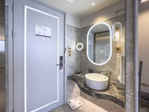 ein Badezimmer mit Waschbecken und Spiegel in der Unterkunft Mercure Beijing Zhongguancun in Peking + 35 Fotos