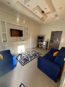 un salon avec deux canapés bleus et une table dans l'établissement Préférence, à Dakar