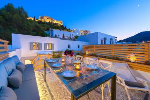 a table on a balcony with a view of a house at Lindos Shore Summer House with Jacuzzi and sea view !!! in Lindos