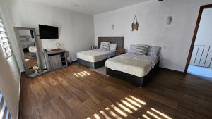 a bedroom with two beds and a television in it at Loft 49 Valquirico in Santeagueda