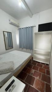 a small room with a bed and a table at Beira Mar Residencial in Capão da Canoa