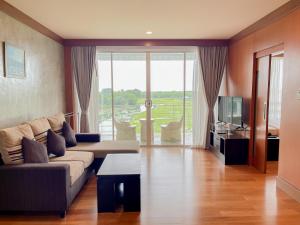 ein Wohnzimmer mit Sofa und Fernseher in der Unterkunft Uniland Golf & Resort in Nakhon Pathom