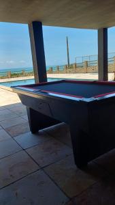 a pool table sitting on a patio near the beach at Villa Búzios in Nísia Floresta