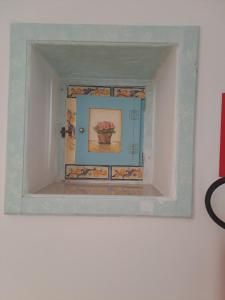 ein gerahmtes Bild einer Vase an einer Wand in der Unterkunft ORTIGIA LUXURIs DOMUs in Syrakus