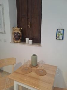 einen Holztisch mit zwei Weingläsern darauf in der Unterkunft ORTIGIA LUXURIs DOMUs in Syrakus
