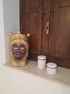 Eine Vase steht auf einem Regal vor einer Tür. in der Unterkunft ORTIGIA LUXURIs DOMUs in Syrakus