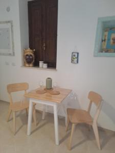 ein Tisch und Stühle in einem Raum mit einem Tisch in der Unterkunft ORTIGIA LUXURIs DOMUs in Syrakus