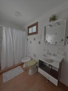 ein Badezimmer mit zwei Waschbecken und einer Toilette und einem Spiegel in der Unterkunft La casita en la playa in Villa Gesell