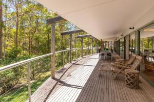 uma varanda envolvente com cadeiras e árvores em Karingal just minutes from Blueys Beach em Charlotte Bay