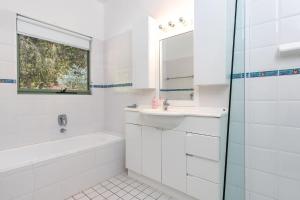 um banheiro branco com uma pia e um espelho em Karingal just minutes from Blueys Beach em Charlotte Bay mais 15 fotografias